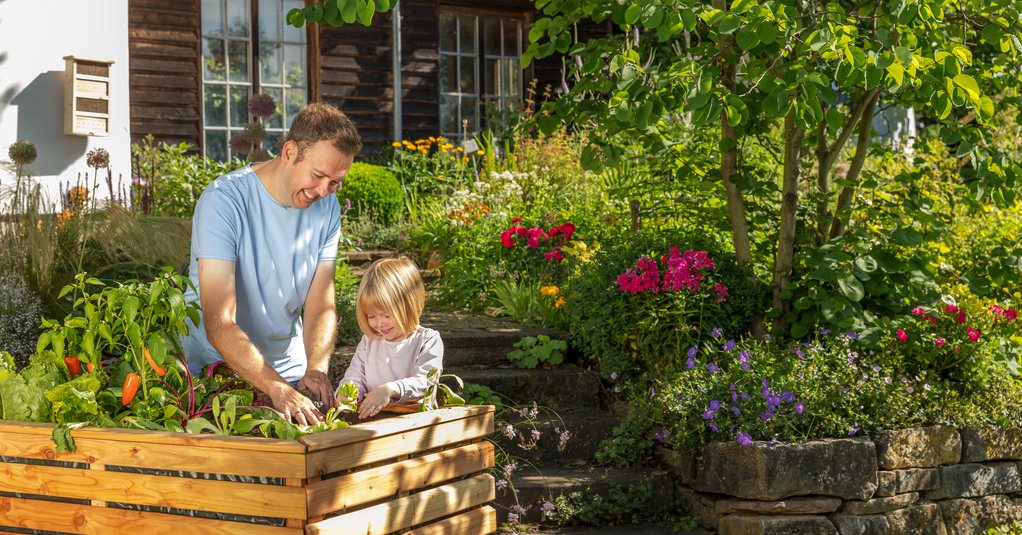 Kind mit Mann am Hochbeet