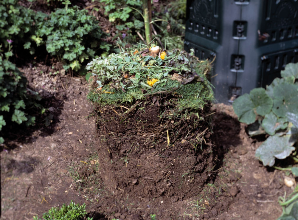 Verschiedene Schichten von Gartenabfällen bis zum fertigen Kompost